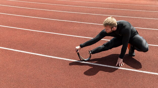 Man with prosthetic leg stretching full shot