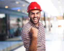 Foto gratuita l'uomo con il casco rosso che celebra con un pugno alzato