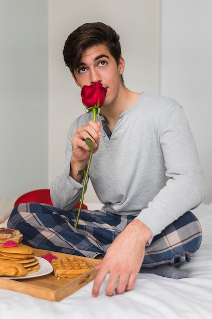 バレンタインの日に赤いバラを持つ男