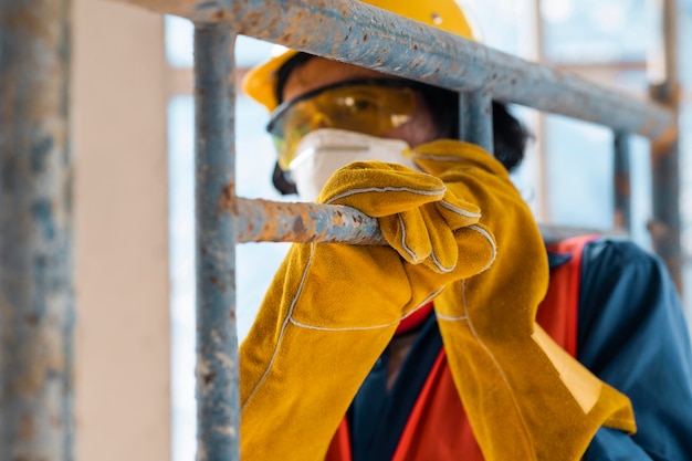 Man with safety equipment side view carrying ladder close up