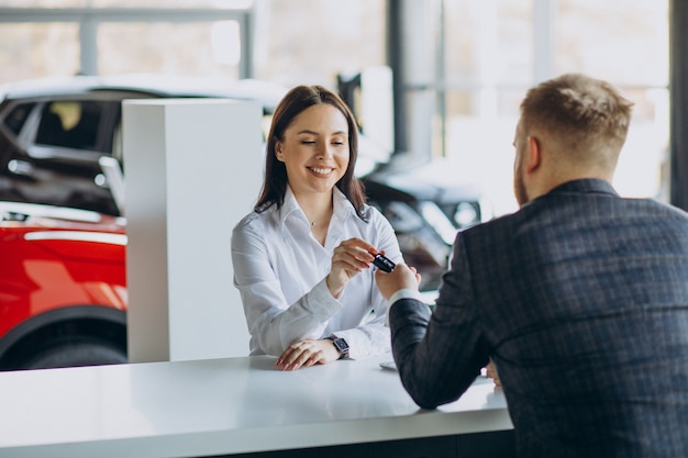 Free photo man with sales woman in car showroom