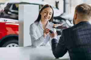 Free photo man with sales woman in car showroom