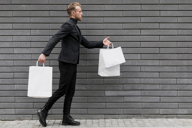 Man with shopping bags walking on street