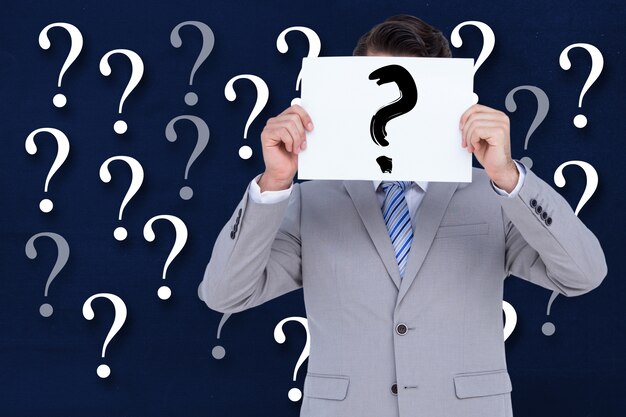 Man with sign with a question mark and a background with question marks