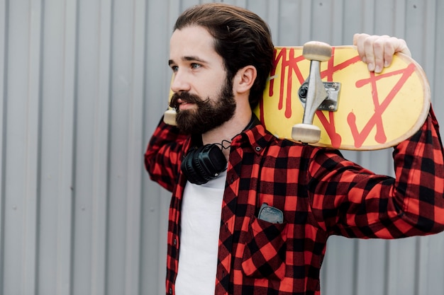 Free photo man with skateboard and headphones