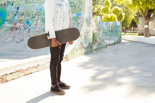 Man with skateboard in urban environment