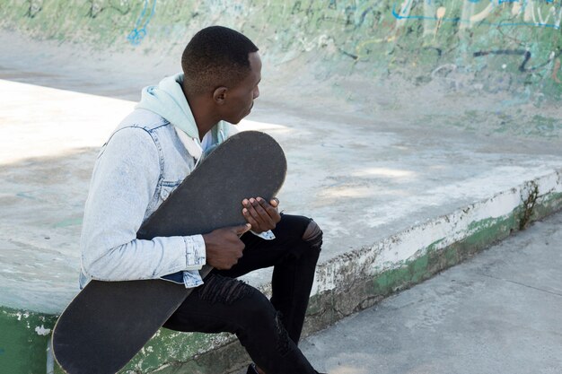 Foto gratuita uomo con skateboard in ambiente urbano