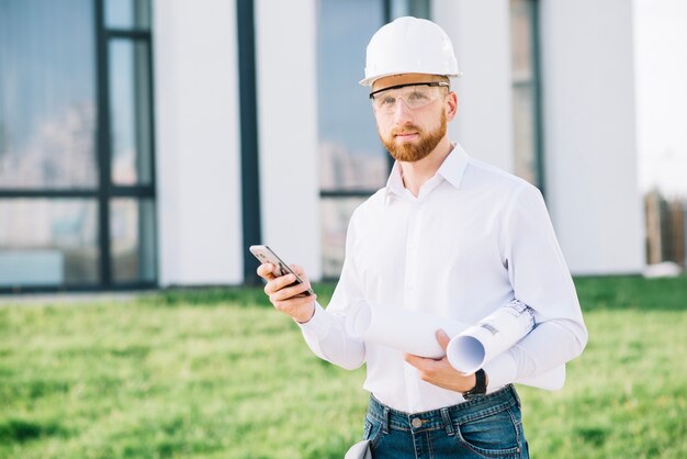 Man with smartphone and drafts