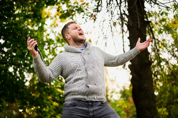 Man with smartphone and earphones in the park