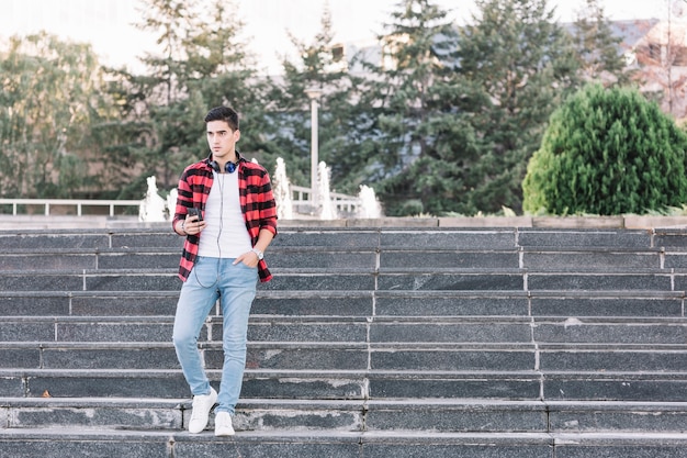 Man with smartphone moving down stairway