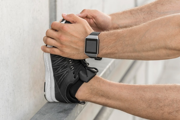 Man with smartwatch stretching outside