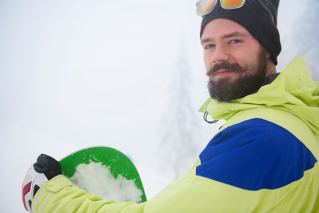 Foto gratuita uomo con lo snowboard durante il periodo invernale