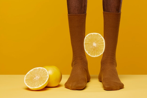 Man with socks having grapefruit at his feet