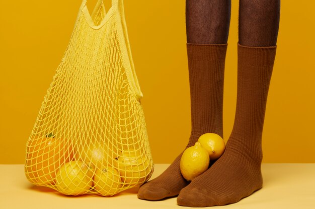 Man with socks having grapefruit and lemons at his feet