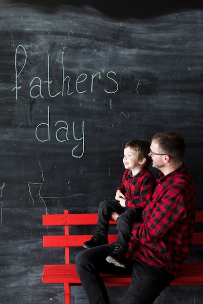Man with son on fathers day in front of blackboard