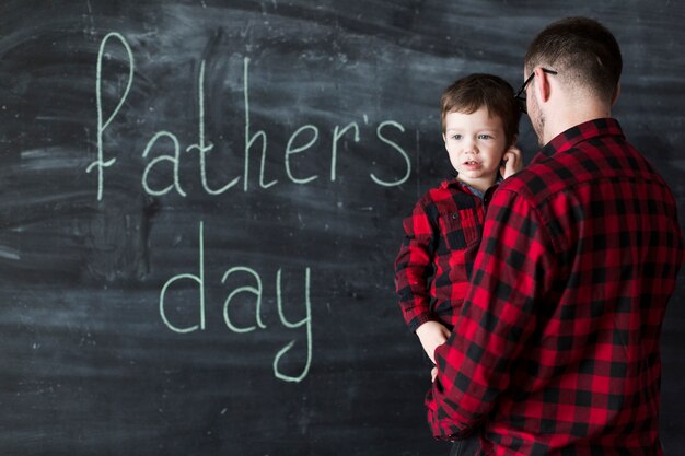 Man with son on fathers day in front of chalkboard