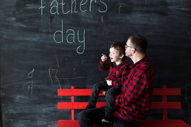 父の日に息子と一緒に黒板の前にいる男
