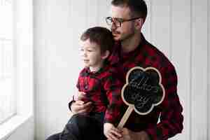 Free photo man with son looking out of window on fathers day