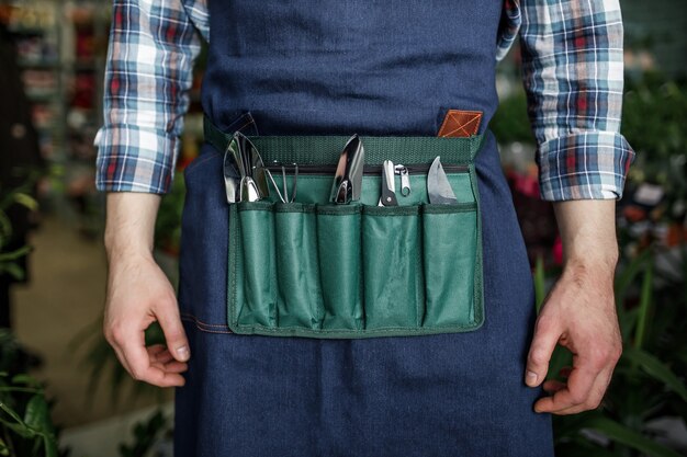 Man with special tool for plant care, ready for spring season planting