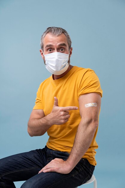 Free photo man with sticker on arm after getting a vaccine