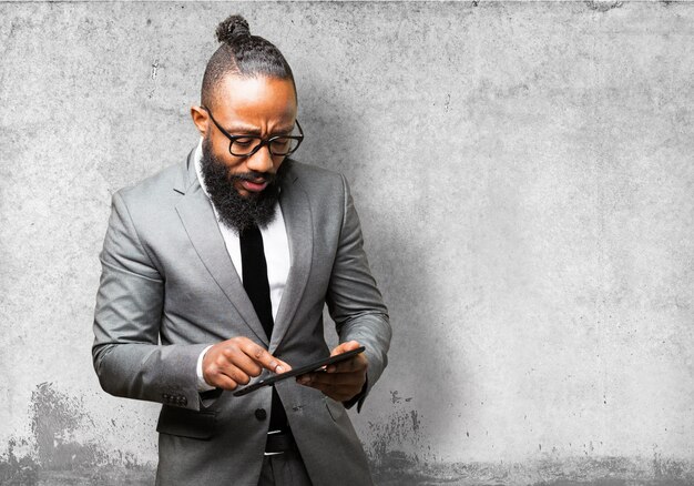 Man with suit touching the screen of a tablet