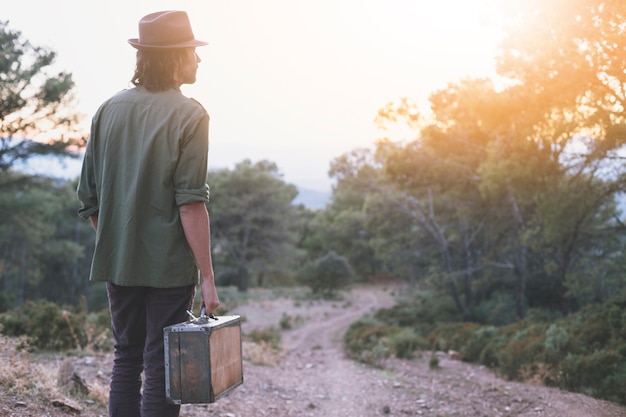 Man with suitcase in countryside