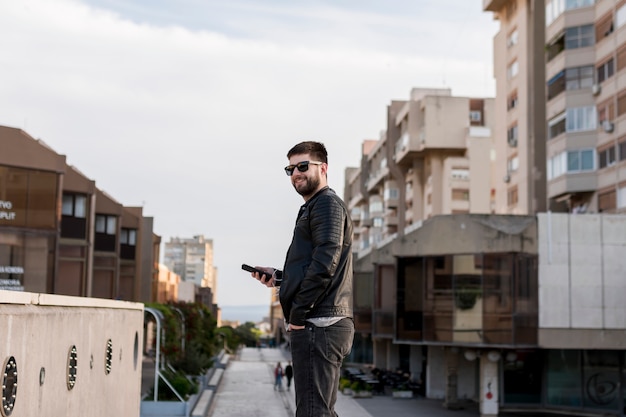 Man with sunglasses holding smartphone