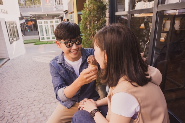 女にアイスクリームを提供するサングラスを持つ男