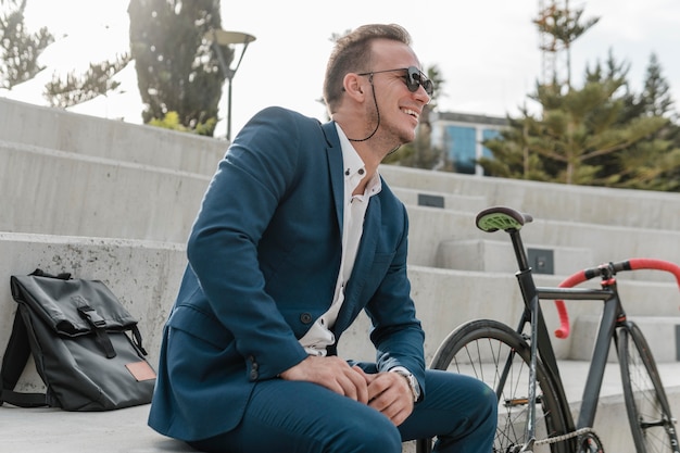 Man with sunglasses sitting next to his bike