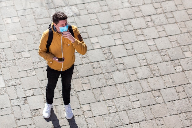 Uomo con maschera chirurgica all'aperto