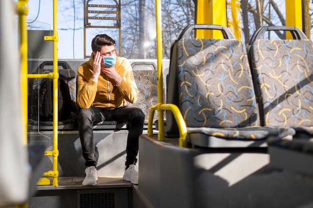 Foto gratuita uomo con maschera chirurgica nel trasporto pubblico