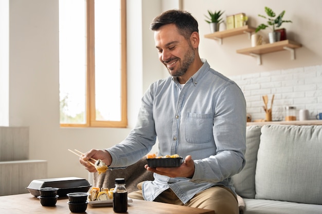 Uomo con un colpo medio di ordine di sushi