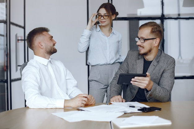 Foto gratuita uomo con una tavoletta. partner commerciali a una riunione di lavoro persone sedute al tavolo