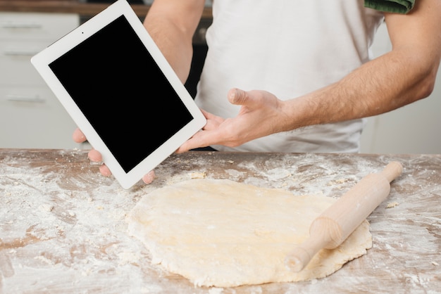 Foto gratuita uomo con tavoletta in cucina