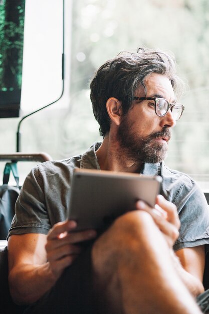 Man with tablet looking away