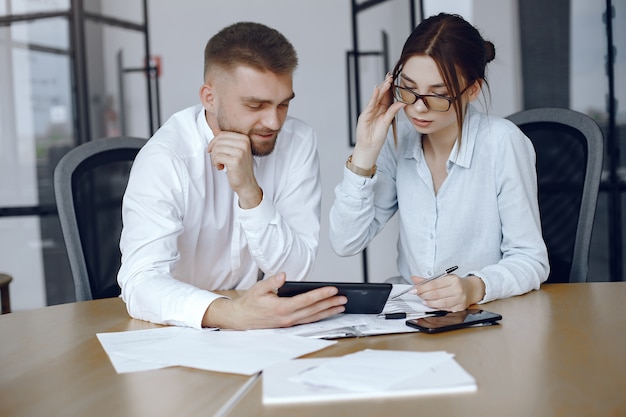 Man with a tablet. Woman with glasses.People sitting at the table