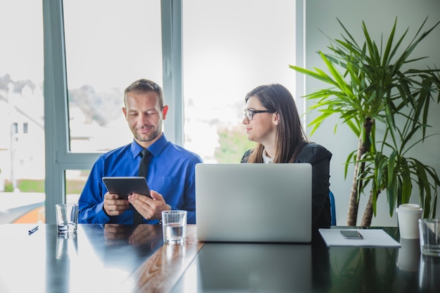 Free photo man with tablet and young coworker