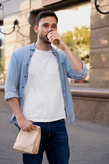 路上で持ち帰り用の食べ物を持つ男