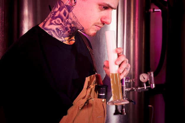 Foto gratuita uomo con tatuaggi che producono birra artigianale