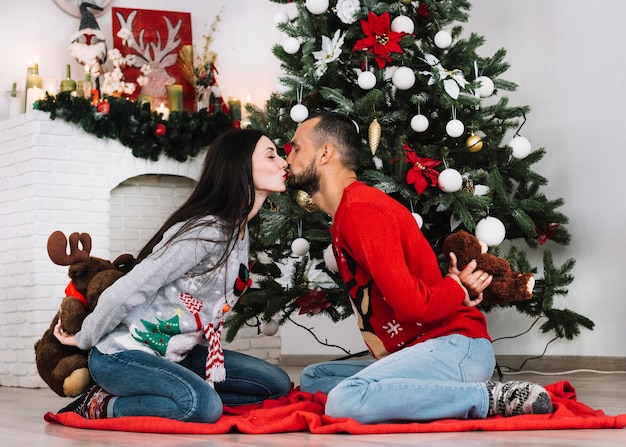 Man with teddy bear kissing woman with fluffy deer