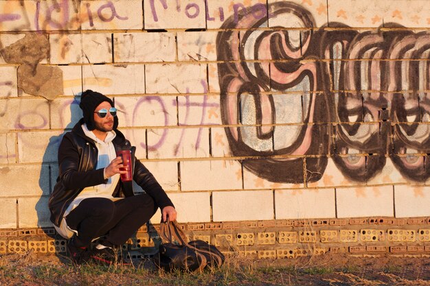 Man with thermos near wall