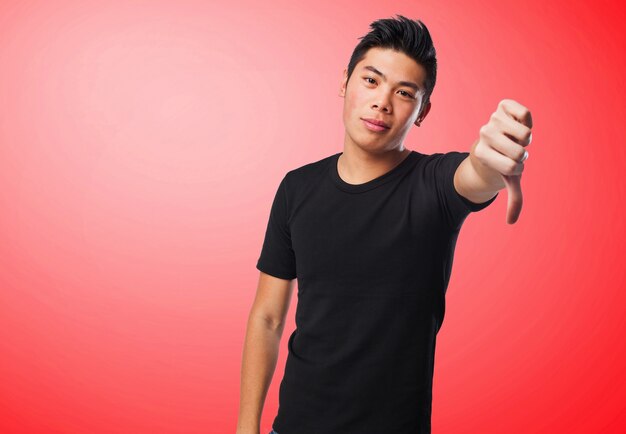 Man with thumb down on a red background