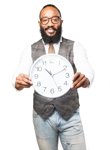 Man with tie smiling and holding a clock