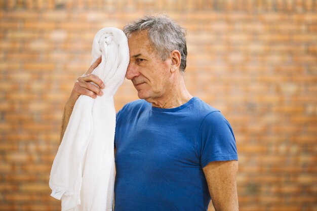 Uomo con un asciugamano in palestra