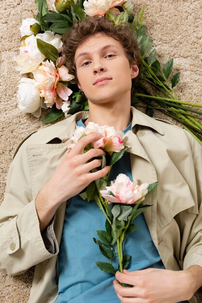 Man with trench coat holding flowers