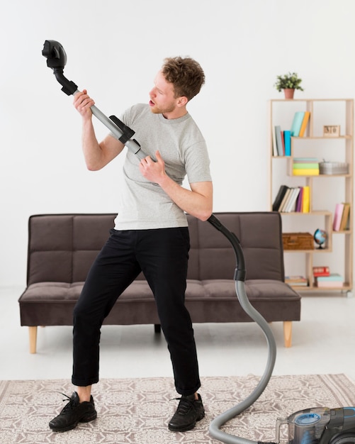 Free photo man with vacuum cleaning