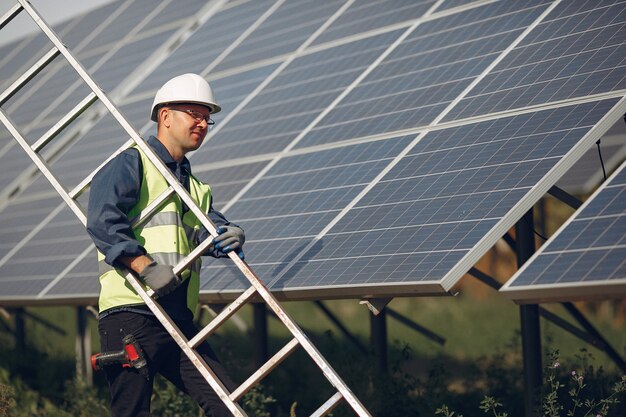 Man with white helmet near a solar panel