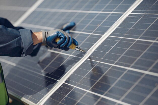 Man with white helmet near a solar panel