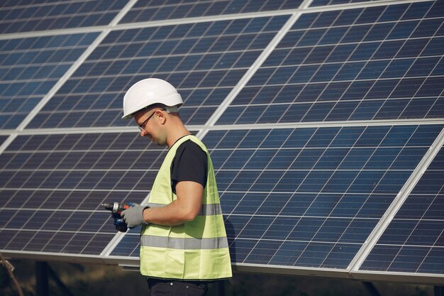 man with white helmet near a solar panel