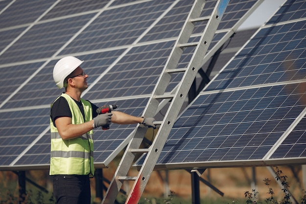 Man with white helmet near a solar panel
